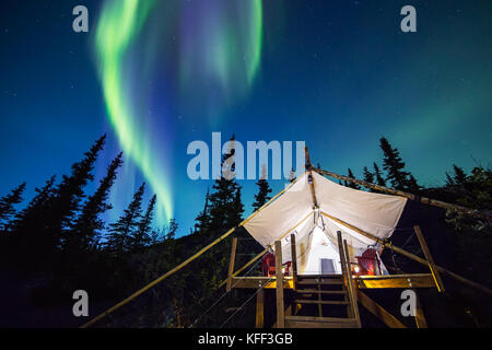 Aurora Borealis over canvas luxury camping tent in Alaska Stock Photo