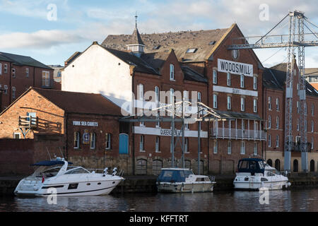 View across River Ouse to pleasure cruisers moored by Woodsmill Quay,  old industrial mill building converted to apartments - York, England, GB, UK. Stock Photo