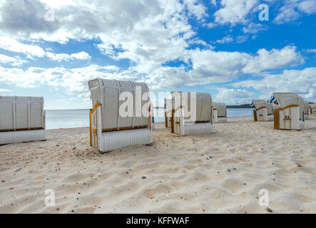 beach scene with beach chairs and blue cloudy sky in Glücksburg, near Flensburg, seaside of the Baltic Sea in North Germany Stock Photo