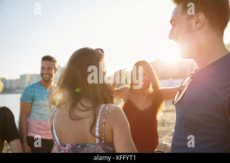 Portrait of happy group of friends dancing on beach Stock Photo