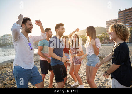 Portrait of young happy people partying on beach Stock Photo