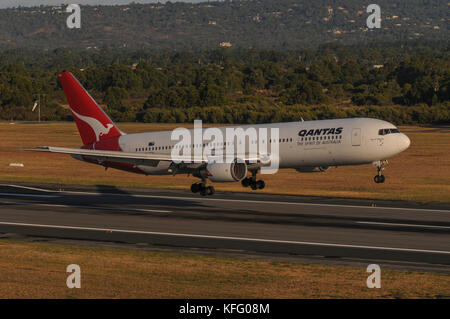 Air-to-ground, semi side-on shot of a Qantas Boeing 767 landing on runway. Aircraft is just hovering above the ground. Stock Photo