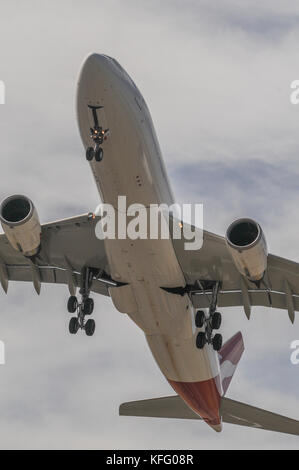 Portrait view, looking up to a Qantas Boeing 767 landing, with undercarriage down. Stock Photo