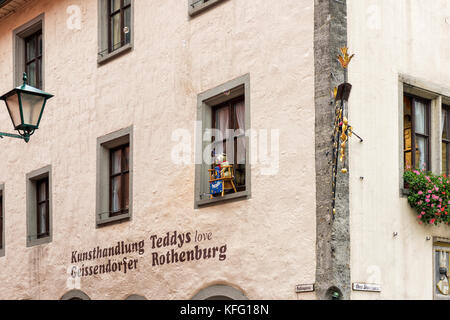 ROTHENBURG, GERMANY - OCTOBER 24, 2017: A small teddy bear sits ona window and creates soap bubbles to attract tourists to an arts shop Stock Photo