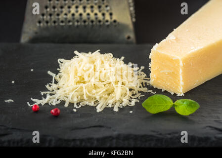 Grated parmesan cheese and metal grater. Stock Photo
