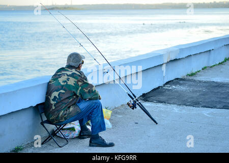 Russia, Saratov - August 9, 2017: An unknown man is fishing on the Volga River embankment in Saratov on August 9, 2017, in Russia. Stock Photo