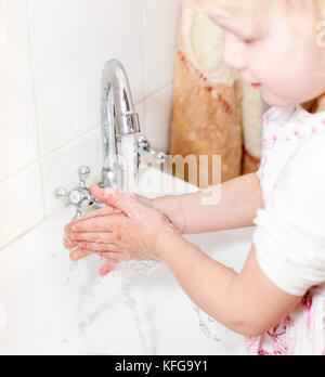 Little girl washing her hands in bathroom, shallow focus Stock Photo