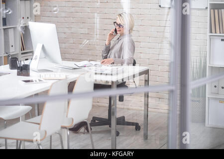 Modern Businesswoman Speaking by Phone in Office Stock Photo