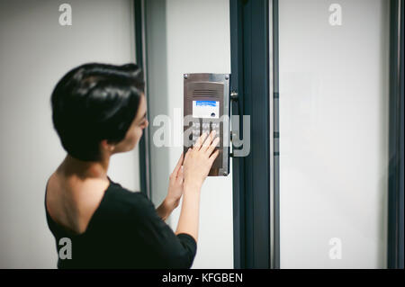 woman is calling on the intercom Stock Photo