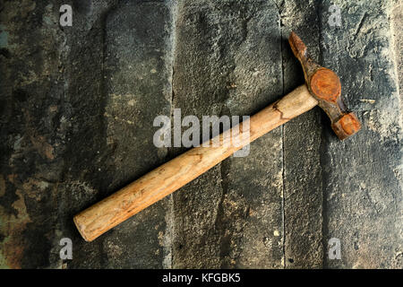 Rusty old hammer on a stone background Stock Photo