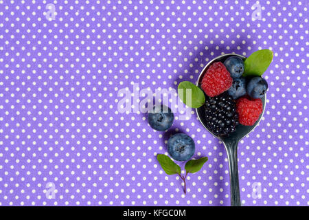 Berries still life on purple spotted background Stock Photo