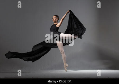 A gorgeous, elegant ballerina in black tights. Studio photography