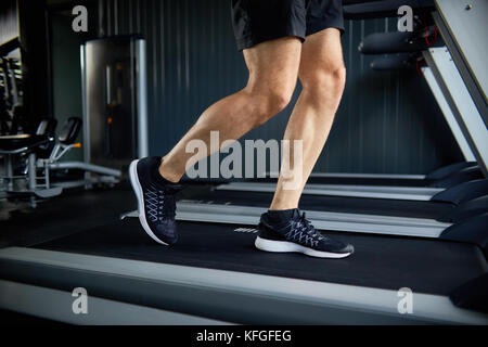 Muscular Legs Running on Treadmill Stock Photo
