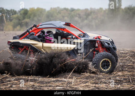 Two pilots in the cockpit of quad bike rushing through the field Stock Photo