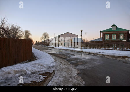 City landscape of Suzdal.Low-rise wooden and brick buildings,The road is covered with asphalt. On the roadside lies the snow.Suzdal.Golden Ring Russia Stock Photo