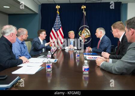 U.S President Donald Trump attends a briefing on Hurricane Harvey relief and recovery efforts joined by Texas Gov. Gregg Abbott, right, Texas Lt. Gov. Dan Patrick and FEMA officials at the White House October 25, 2017 in Washington, DC. Stock Photo
