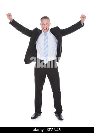 Exultant stylish young businessman in a suit jumping and raising his ...