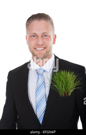 Smiling businessman with a fresh green plant in his pocket in place of a folded handkerchief in a conceptual image  isolated on white Stock Photo