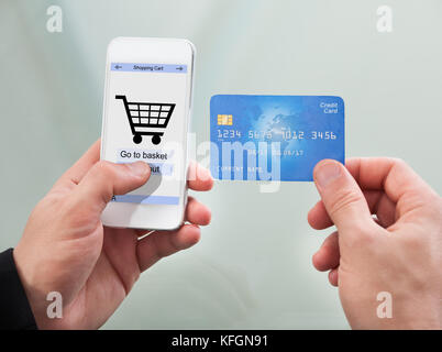Close-up Of Man Paying With Credit Card On Mobile Phone Stock Photo