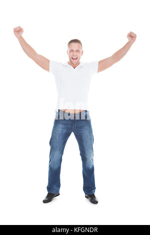 Handsome man cheering in exultation punching the air with his fists as he celebrates good news  full length isolated on white Stock Photo
