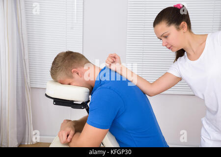 Young Man Being Massaged By A Female Physiotherapist Stock Photo