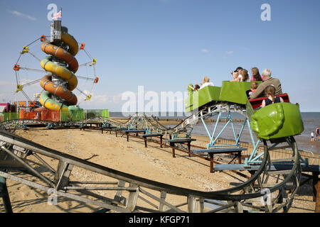 Ferris wheel, helter-skelter and rollercoaster on Cleethorpes beach, UK. Stock Photo