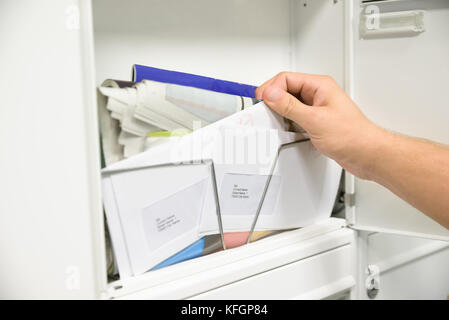 Close-up Of Man's Hand Taking Letter From Opened Mailbox Stock Photo