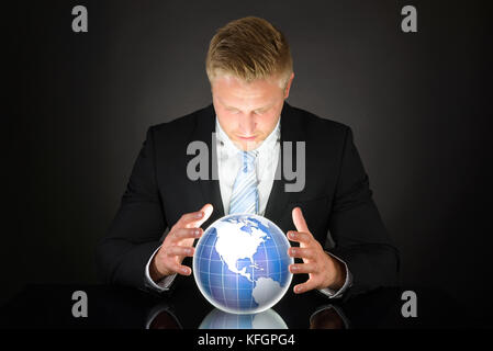 Portrait Of Young Adult Businessman Looking At Globe Stock Photo