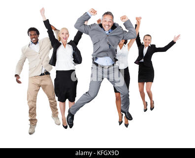 Portrait of successful business team with arms raised standing over white background Stock Photo