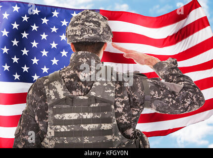 Rear View Of A Soldier Saluting American Flag Stock Photo