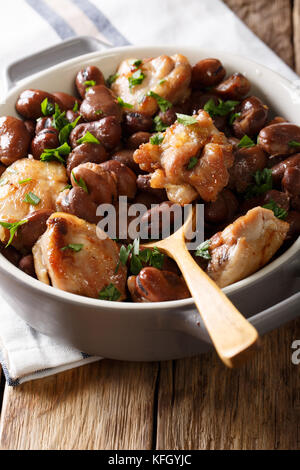 Homemade chicken baked with broad beans close-up in a bowl on the table. vertical Stock Photo