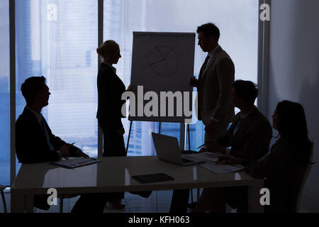 Silhouette of business people having a discussion in conference room Stock Photo