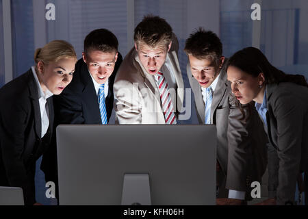 Surprised young business people looking at computer monitor in office Stock Photo
