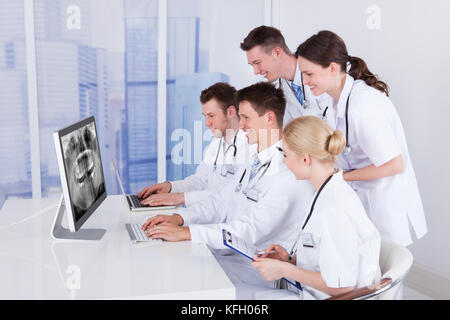 Team of dentists examining jaw Xray on computer in hospital Stock Photo