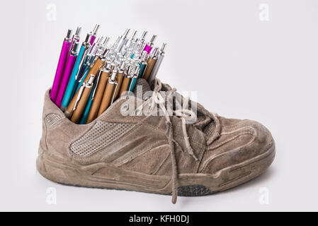 Stack of pens inserted to the old  wear out sneaker Stock Photo