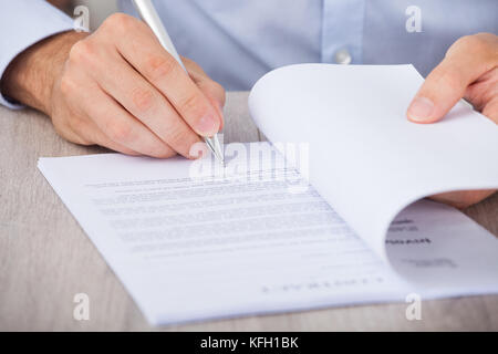 Cropped image of businessman signing contract at desk Stock Photo