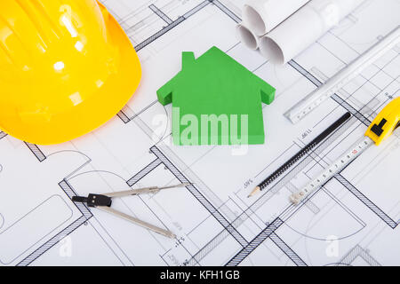 Closeup of tools; hardhat and model house on blueprint Stock Photo