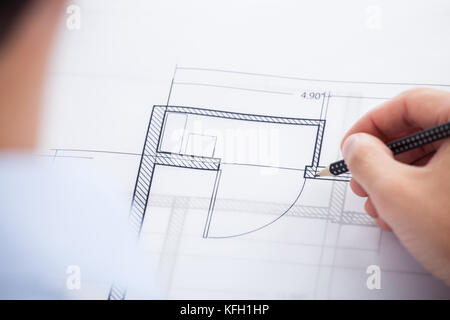 Cropped image of architect working on blueprint in office Stock Photo