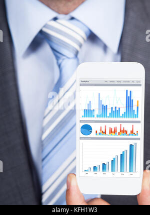 Closeup of businessman showing graphs on smartphone Stock Photo