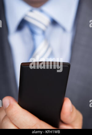 Closeup photo of businessman using his smartphone Stock Photo