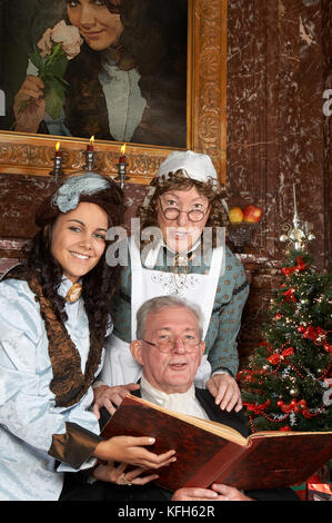 Vintage christmas scene of a victorian family singing christmas carols. Shot in the antique castle 'Den Brandt' in Antwerp, Belgium (with signed prope Stock Photo