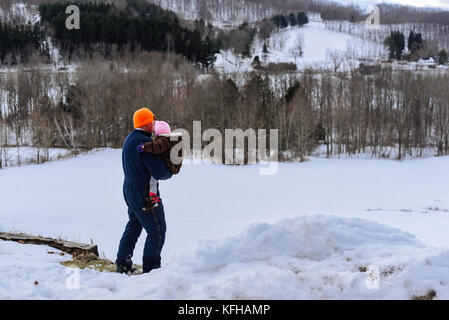 Man holding infant in winter with snow Stock Photo