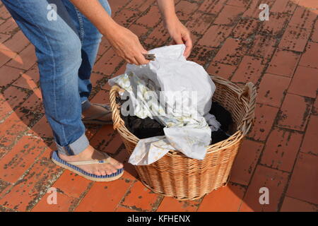 Woman with a basket full of wet laundry to be hung to dry Stock Photo