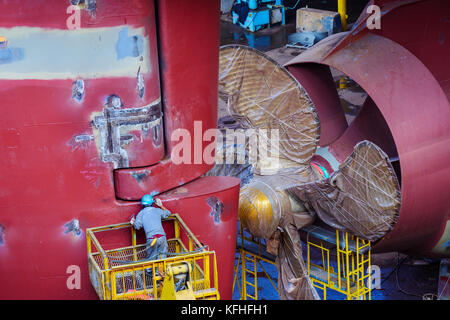 A technician expecting the rudder of the ship under construction in dockyard Stock Photo