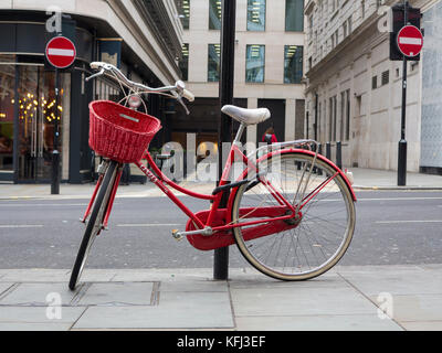 An elegant lady's red bicycle chained to a lampost in central London Stock Photo