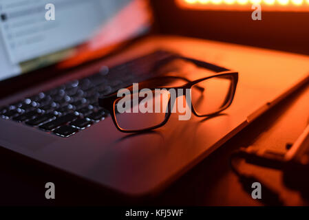 Glasses and a laptop on the table Stock Photo