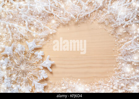 White frosty branches, covered with snow, snowflake and round copy space on natural unpainted wooden background. Stock Photo
