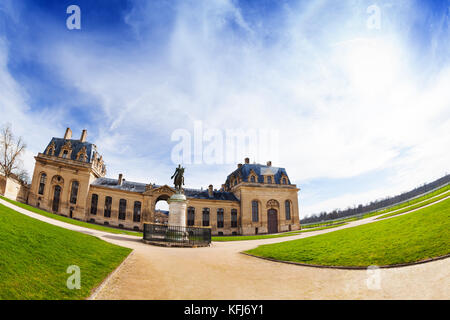 Fish-eye picture of Great Stables building with equestrian statue of Henri d'Orleans in the foreground, Chateau de Chantilly, France Stock Photo