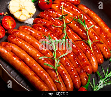 Closeup of Wiener Sausages with vegetables in a pan Stock Photo