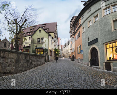 ROTHENBURG, GERMANY - OCTOBER 24, 2017: An unidentified lady walks along a medieval alley during the blue hour Stock Photo